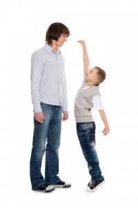 Kid trying to measure up to his older brother